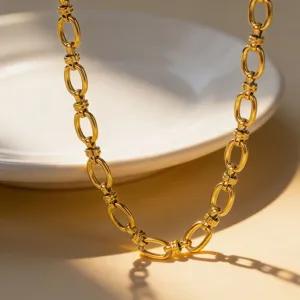 Close-up detail of gold plated chunky chain necklace, metallic texture link jewelry piece.