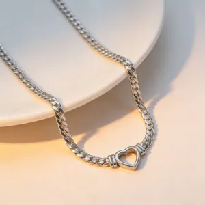 Close-up van een zilveren platte slangketting halsketting met een hol hart hangertje