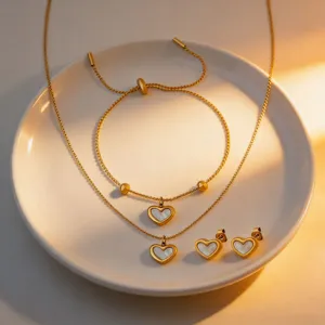 Detailed close-up of gold-plated heart jewelry set featuring necklace, bracelet and studs.