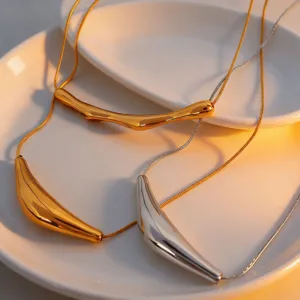 Detailed close-up of geometric irregular titanium steel arc tube necklace in gold and silver.