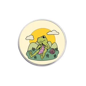 Gros plan detaille du pin's en metal grenouille mignon, joli badge motif tricot.