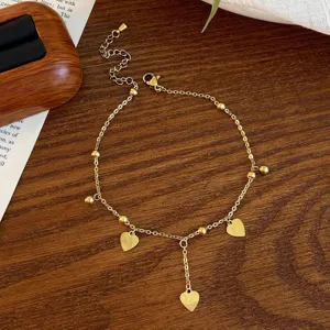 Delicate gold heart anklet with cute bead charms and tassel design, perfect for women's daily wear.