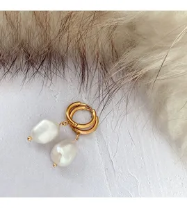Close-up view of minimalist stainless steel irregular pearl hoop earrings detail.