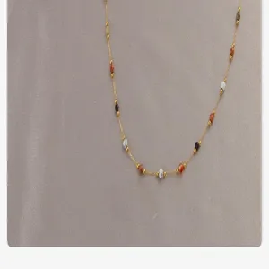 Délicat collier chaîne doré avec perles de pierres naturelles multicolores, gros plan détaillé.
