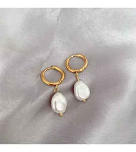 Close-up detail view of elegant irregular pearl hoop earrings showcasing the premium texture.