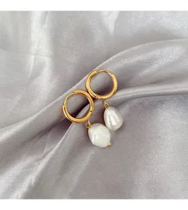 Detailed view of French stainless steel gold hoop earrings featuring elegant irregular baroque pearls.