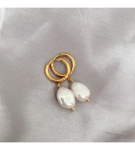 Close-up detail of elegant gold hoop earrings featuring stunning irregular white pearl pendants.