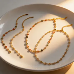 Gold-toned titanium steel necklace featuring colorful painted daisy flower charms for summer.