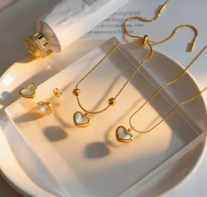 Gold titanium steel white shell heart jewelry set including earrings and pendant necklace.