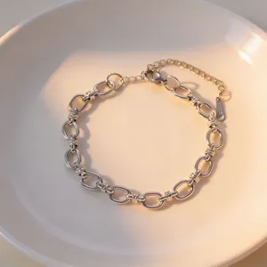 Detailed closeup of a trendy stainless steel interlinked chain bracelet with extension tail.