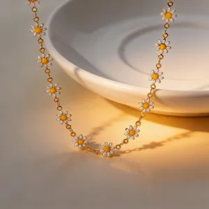 Close-up detail shot of a cute daisy enamel chain necklace featuring white petals and yellow centers.