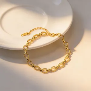 Gold chunky chain bracelet detail, interlocking oval links design with extension tail chain.