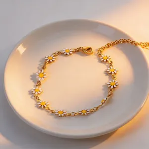 Gold titanium steel daisy chain bracelet with white and yellow enamel flower charms for women.