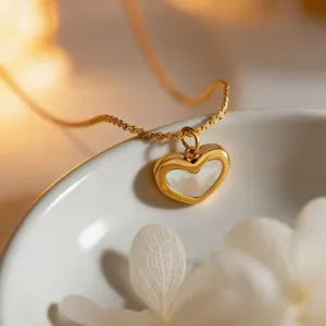 Close-up detail view of the elegant mother-of-pearl puffy heart pendant necklace in gold tone.