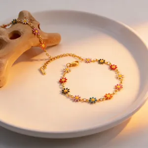 Close-up detail of colorful enamel daisy flower gold-plated chain necklace or bracelet display.