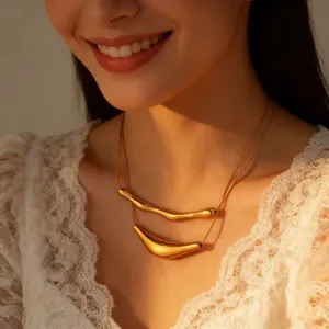 Close-up shot of a stylish double-layer gold geometric curved tube necklace on model.