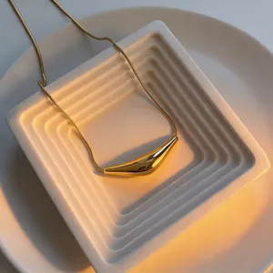 Gold geometric curved tube pendant necklace detail shot, elegant titanium steel accessory.