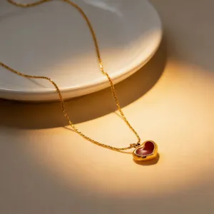 Exquisite gold stainless steel necklace featuring a stylish red heart pendant detail shot.