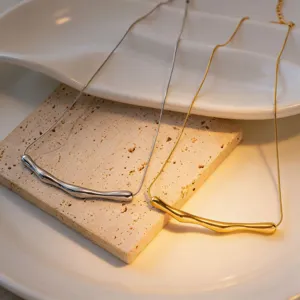 Detailed shot of irregular curved tube necklace in silver and gold minimalist style
