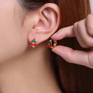 Close-up of cute cherry enamel huggie hoop earrings, gold plated stainless steel detail shot.