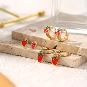 Detailed shot of stainless steel fruit earrings set featuring cute strawberry and cherry designs.