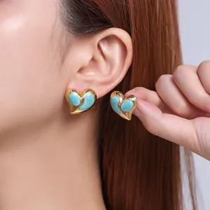 Close-up detail of chic enamel heart titanium steel earrings, gold-plated fashion jewelry.