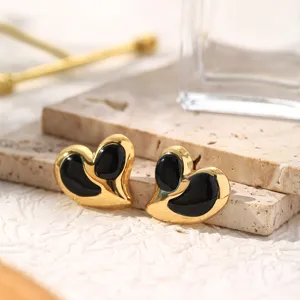 Detailed close-up of gold-plated heart titanium steel earrings with black enamel inlay texture.
