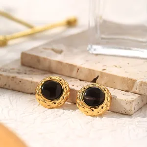 Close-up detail of luxury 18k gold plated titanium steel stud earrings with black cat eye stone.