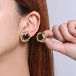 Detailed view of luxury stainless steel 18K gold plated round earrings with black cat's eye.