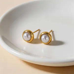 Minimalist gold-rimmed pearl stud earrings detail shot, elegant light luxury titanium jewelry.