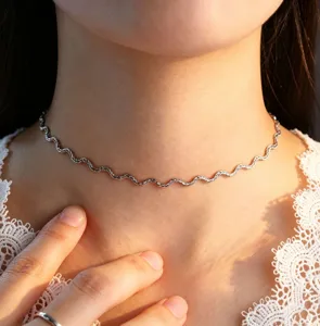 Wavy chain choker necklace detail shot showcasing delicate metallic curve design for women.