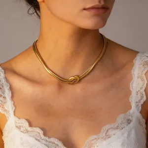 Dettaglio collana a catena serpente con nodo dorato, stile punk e design geometrico per clavicola.