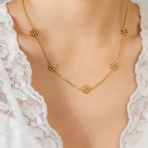 Close-up detail of the delicate gold-plated daisy flower chain necklace worn by model.