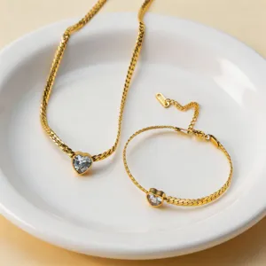Detailed close-up of gold-plated titanium steel heart-shaped zircon necklace and bracelet set.
