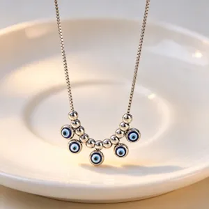 Silver evil eye pendant necklace detail shot, minimalist stainless steel jewelry for women.