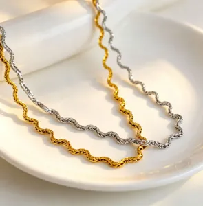 Detail shot of wavy stainless steel necklace set in gold and silver, elegant 18k gold plated choker.