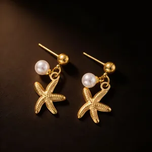 Gold starfish pearl earrings detail shot showcasing delicate ocean beach vacation jewelry design.