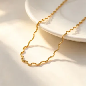 Detailed shot of a sleek gold-plated wavy chain necklace, elegant and modern everyday jewelry.