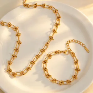 Collier et bracelet torsadés en acier au titane plaqué or 18k exquise vue détaillée.