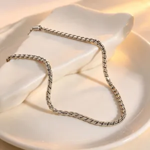 Detailed closeup of the elegant silver rope chain jewelry displayed on a white ceramic tray.