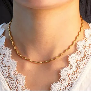 Wavy gold chain necklace detail close up view, elegant stainless steel choker jewelry design.