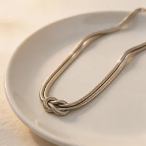 Collana girocollo con nodo in acciaio inossidabile, dettaglio gioiello geometrico punk in metallo.