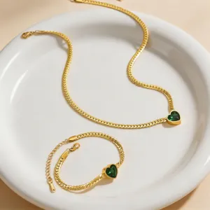Elegant gold-plated herringbone chain necklace and bracelet set featuring green heart gemstones.