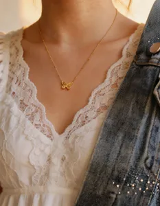 Close-up shot of the gold butterfly pendant necklace showcasing delicate beaded chain details.