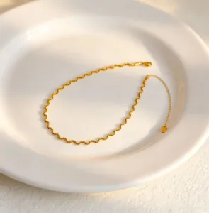 Close-up detail of the wave-pattern gold-plated stainless steel chain with extension.