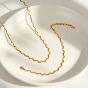 Gold wavy chain detail shot, stainless steel necklace and bracelet set close up view.