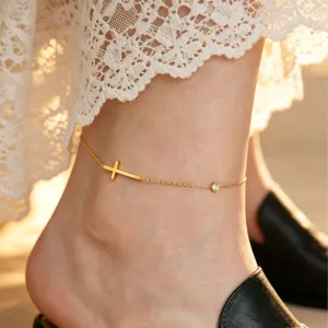 Gold stainless steel cross anklet detail shot, elegant crystal charm fashion jewelry.