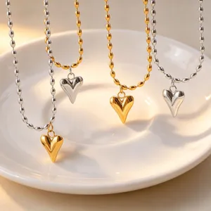 Gold and silver heart pendant necklace detail, titanium steel rice bead chain close-up view.