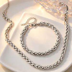Close-up detail of silver braided chain necklace and bracelet set beautifully displayed.