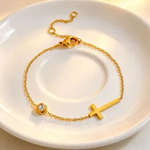 Detailed view of gold cross bracelet featuring minimalist titanium steel with single stone.